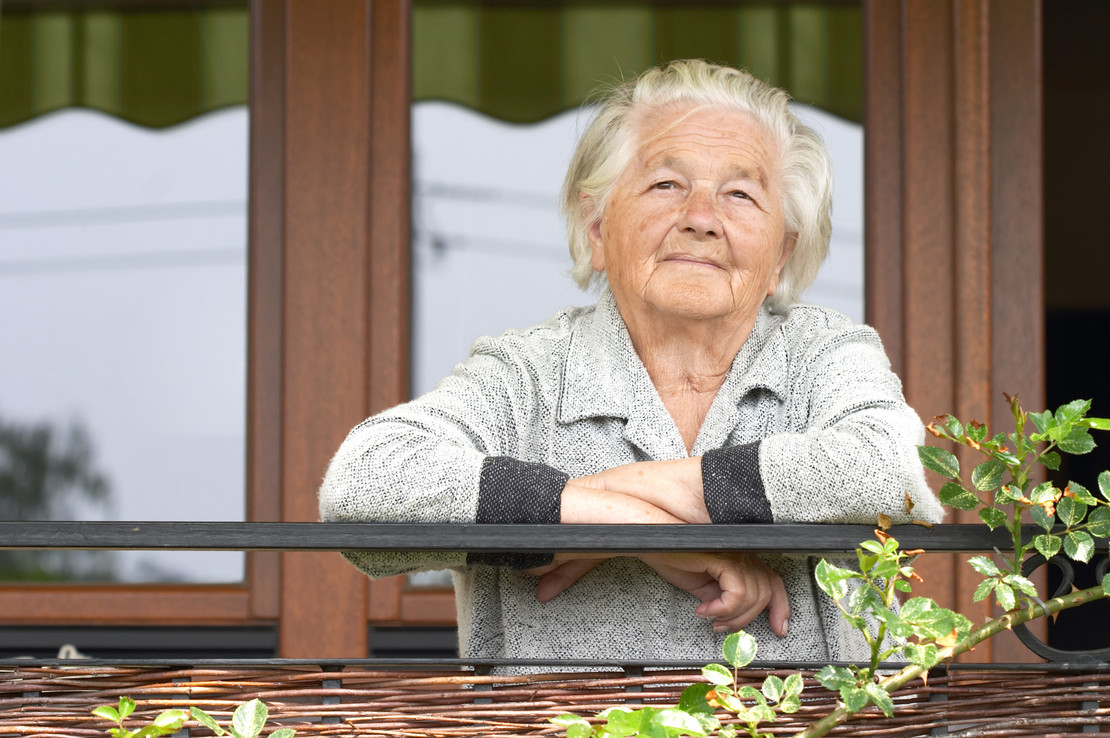 Ältere Frau blickt dem Betrachter entgegen. 